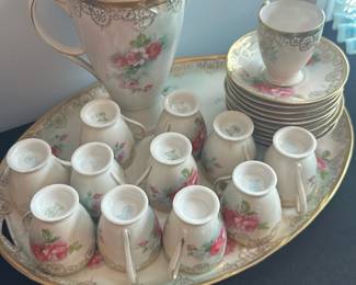 C.T. Altwasser Prussia Porcelain Set — This elegant C.T. Altwasser porcelain coffee set from Prussia features a delicate floral pattern accented with gold trim. The set includes a tall coffee pot with lid, twelve matching cups with handles, and twelve saucers, all resting on a large serving tray. Each piece is marked with the green C.T. Altwasser Prussia hallmark, signifying its classic craftsmanship. The pieces are in good condition with minor wear normal for vintage porcelain, and no visible chips or cracks. This charming set is perfect for collectors or those looking to add a vintage European touch to their dining experience.