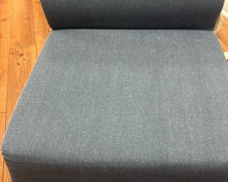 Blue Upholstered fold out  Chair — This versatile blue upholstered chair is designed for comfortable seating, ideal for basement or casual living areas. Featuring a simple block form with a rounded backrest, the chair is covered in a durable blue fabric. Its compact size makes it suitable for smaller spaces or as additional seating. The chair appears to be in good condition with minor wear from normal use. Perfect for someone seeking functional and cozy furniture for informal settings.