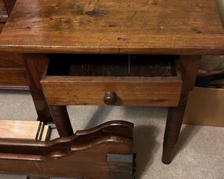Antique Wood Side Table — This antique wood side table features a classic design with a single drawer and turned legs that showcase traditional craftsmanship. Made of solid wood with a rich, warm patina, it offers both functional storage and charming decor appeal. The table measures approximately 24 in height, 24 in width, and 20 in depth, making it a versatile piece for bedroom or living areas. It is in good condition with visible wear consistent with age, adding character but no structural damage. This piece reflects a timeless style suitable for vintage collectors or home furnishing enthusiasts.