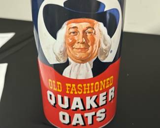 Quaker Oats Ceramic Canister — This vintage Quaker Oats ceramic canister features the iconic Quaker man logo with a red and blue color scheme. Designed as a kitchen storage container, it has a removable lid that fits snugly to keep contents fresh. The canister measures approximately 7 inches tall and 4 inches in diameter, making it a practical yet decorative piece for the kitchen or pantry. It shows some signs of use with minor staining on the lid rim but remains in good overall condition. A nostalgic collectible for fans of classic kitchenware and vintage advertising.