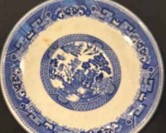 Buffalo Pottery Blue Willow Plate — This distinctive Buffalo Pottery Blue Willow plate features classic blue and white transferware design with intricate scenic patterns typical of the Blue Willow style. Made from semi-vitreous china, it presents an elegant and durable form with visible crazing that adds vintage character. The plate measures approximately 10.25 inches in diameter, ideal for display or dining use. It is in good vintage condition with minor staining and typical wear from age, consistent with the semi-vitreous finish. Buffalo Pottery was a prominent manufacturer known for quality American ceramics in the early 20th century, making this plate a collectible piece.