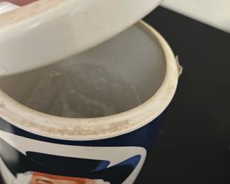 Quaker Oats Ceramic Canister — This vintage Quaker Oats ceramic canister features the iconic Quaker man logo with a red and blue color scheme. Designed as a kitchen storage container, it has a removable lid that fits snugly to keep contents fresh. The canister measures approximately 7 inches tall and 4 inches in diameter, making it a practical yet decorative piece for the kitchen or pantry. It shows some signs of use with minor staining on the lid rim but remains in good overall condition. A nostalgic collectible for fans of classic kitchenware and vintage advertising.