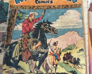 Red Ryder Comics July Issue — Red Ryder comic book featuring classic western cover art (July issue). Softcover pulp comic with full-color illustrated cover showing cowboys and horses; paper stock shows age and edge wear. Comic measures approximately 10.5 inches tall by 7.25 inches wide with light creasing, a clipped lower-right corner, and some spine/tip chipping typical of well-read Golden Age/early paperback comics. Overall condition is fair with visible wear, discoloration, and surface marks but intact center staples and readable interior pages.