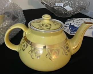 Hall Yellow Teapot with Floral Design — This charming Hall teapot features a glossy yellow glaze adorned with delicate floral motifs and a gold band accentuating its mid-century elegance. Crafted from high-quality ceramic, it bears the Hall mark and 'Made in U.S.A.' stamp on its base, confirming its authenticity and vintage origin. The teapot measures approximately 5.5 inches in height, 8.5 inches in width (handle to spout), and 4.5 inches in depth, making it a functional yet decorative piece for any kitchen or collection. It is in good condition with minor wear on the gold trim consistent with age but no visible chips or cracks. A classic piece from Hall Pottery, perfect for collectors of American vintage ceramics or tea enthusiasts.