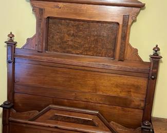 Antique Carved Mahogany Bed Frame — This antique full size bed frame features beautifully carved mahogany with an intricate design and decorative finials. The solid wood construction highlights a rich, warm finish with a distinctive headboard panel and ornate cresting. Measuring approximately 60 inches wide, 80 inches long, and 72 inches high, it offers a sturdy and elegant centerpiece for a bedroom. The frame is in good condition with minor wear consistent with its age, showing no structural damage. This piece exemplifies classic craftsmanship and would suit traditional or vintage-style interiors.