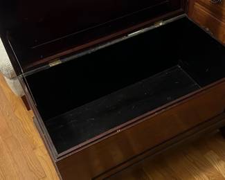 Mahogany Storage Blanket Chest — Solid mahogany blanket chest with a hinged lift-top and decorative carved ball-and-claw feet, shown in the master bedroom. The top has an inset panel protected under plexiglass and the interior is finished in dark paint for storage. Measures approximately to fit a standard bedroom footprint and offers practical storage for linens or blankets. Shows surface scratches and wear to finish consistent with age but structurally sound; hinges functional.