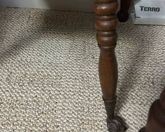 Vintage Oak Accent Table with claw foot — This vintage oak accent table features intricately turned legs and a lower shelf The rich oak finish highlights the wood grain and adds warmth to any bedroom or living room. Measuring approximately 28 in height, 18 in width, and 12 in depth, this compact table offers decorative charm and practical surface space. It is in good condition with minor signs of wear consistent with age and use, and A lovely piece reflecting early 20th-century style and craftsmanship.