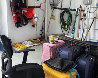 Office chair, vintage yellow laundry hamper, suitcases, yard tools