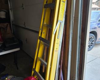 yellow Werner fiberglass ladder features aluminum rungs and a high-visibility safety sticker.