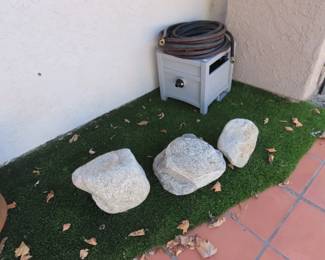 Large decorative natural rocks, hose and hose house.