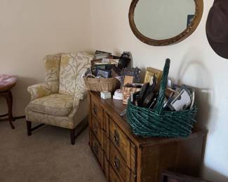 There are two big baskets of different size beautiful frames. There is a great dresser, a high back wing chair, a wonderful mirror and a table with two large baskets filled with costume jewelry sold in Bags.