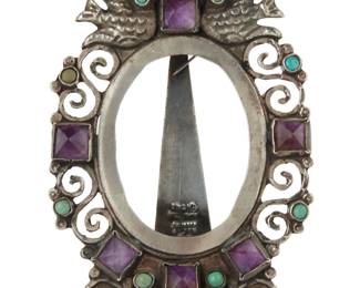 5 Gustavo Martinez (b. 20th Century, Mexican) A Mexican sterling silver frame with set gemstones Mid/late 20th century, Mexico Stamped to stand: GM 0.925 / Hecho en Mexico / COY D. F. Sterling / Mexico / [coyote picto] The diminutive sterling silver frame in a Matl/Matilde Poulat-style with dove motifs, scrolled hammered wire work and set amethyst and turquoise stones 3.5" H x 2.375" W x 0.375" D; oval opening: 1.875" H x 1.375" W 35.2 grams gross Estimate: $200 - $400
