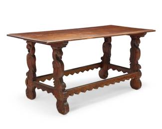 81 A Spanish Colonial-style table 19th/early 20th century The ogee edge top raised on carved bird-form trestle legs, joined by a shaped box stretcher 32" H x 67.5" W x 31" D Estimate: $800 - $1,200