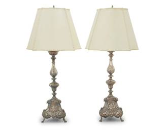 257 A pair of Spanish Colonial style sterling silver candlesticks as lamps 19th century with later elements Each marked: LAGOUTTE A LYON; XRF tested for sterling Each weighted sterling candlestick with repoussé Baroque-style floral, bellflower, and scrolled motifs, converted into a single-light table lamp surmounted by a hide shade, electrified 2 pieces Each candlestick: 21" H x 8" W x 6.75"; Each shade: 12" H x 16" W x 16" D Estimate: $1,000 - $1,500