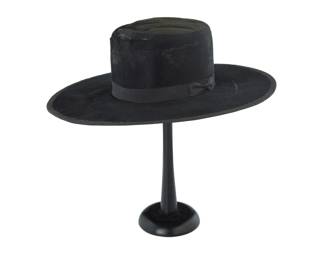 35 A Mexican black beaver fur Caballero sombrero Circa 1865-85 The black fur felt flat crown hat with 4 1/2 inch flat brim and grosgrain ribbon band with bow, the edges with grosgrain trim, and with interior leather sweat band and later black satin lining 5" H x 15.75" W x 17" D; Inner band: 21.5" C Estimate: $1,200 - $1,800