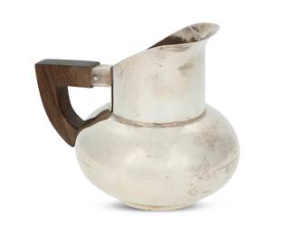 262 A José Anton sterling silver creamer José Anton (20th Century, Mexican) Mid-20th century; Taxco, Mexico Impressed to underside: ANTON / STERLING / TAXCO With wood handle 4" H x 4.75" W x 3.625" D 7.8 gross oz. troy approximately Estimate: $300 - $500