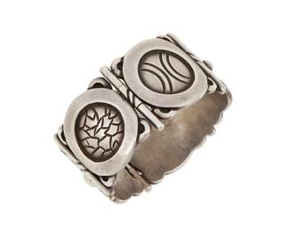 274 Hector Aguilar (1905-1986, Mexican) A Mexican sterling silver link bracelet Circa 1940-1945; Taxco, Mexico Stamped: HA [conjoined] / 940 / Taxco A chunky sterling silver curved two-link oval hinged bracelet with various Aztec and geometric motif roundels, with pin clasp and chain 6.75" inner C x 1.375" H 109.2 grams Estimate: $700 - $900