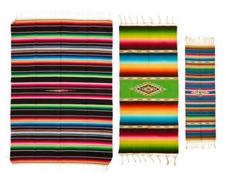 107 Three Mexican sarapes Mid/late 20th century Comprising two sarapes finely woven in multicolored wool, each with a central serrated diamond amid multiple ombre shaded colored bands, with elaborate knotted fringing to each end, as well as a larger cotton sarape with vibrant multicolored bands and knotted cotton fringe to each end 3 pieces Largest: 83" H x 58.75" W; Smallest: 58.5" H x 19" W approximately (excluding fringe) Estimate: $100 - $200
