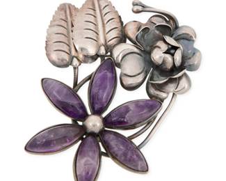 286 A Mexican silver and amethyst floral brooch Mid-20th century Stamped: Mexico / Silver A sterling silver brooch with incised leaves and a dimensional silver flower, and a flower with six set carved amethyst petals 3.5" H x 2.5" W 46.1 grams gross Estimate: $200 - $400