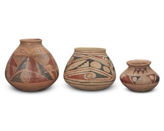 143 Three Casas Grandes-style polychrome pottery ollas Mid-20th century One deeply incised to underside: Manuel Olivas Comprising one by Manuel Olivas (b. 1940, Mata Ortiz) and two others, each with red and black geometric motifs on a cream slip ground, one with corrugated neck 3 pieces Largest: 8.375" H x 8.375" Dia.; Olivas: 7" H x 8.25" Dia.; Smallest: 5" H x 6.125" Dia. Estimate: $200 - $400
