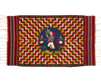41 A Mexican Aggregate Period pictorial sarape of Santa Anna Late 19th century Woven with wool weft on cotton warp in tones of blue, green, yellow, and red, in two panels seamed down the middle featuring a central medallion depicting Santa Ana, flanked by two large flowers on a multicolored geometric block patterned field with a floral garland border and striped banded ends with long fringing 78.5" H x 45.5" W approximately Estimate: $2,000 - $3,000
