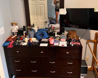 7 drawer dresser with mirror, porcelain doll, knick knacks, travel pillows, steampunk goggles, neck gators, statues