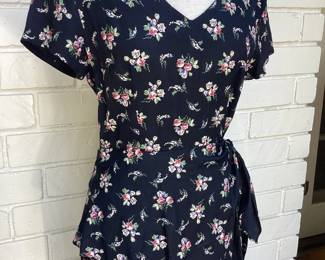 Vintage Floral Wrap Dress Classic vintage wrap-style dress with delicate floral print on a navy background. Features a feminine V-neckline, waist tie, and flattering silhouette that's perfect for everyday wear or vintage-inspired styling.