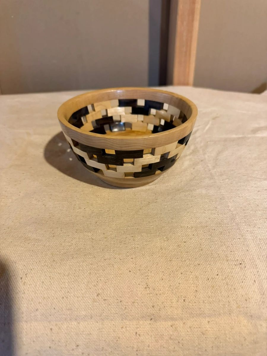 Decorative open-weave segmented wood basket handcrafted from contrasting hardwoods. Stunning artisan woodworking perfect for display or serving.