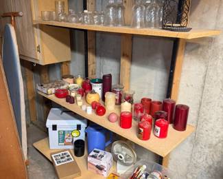 Shelving full of candles, glass jars, decorative bottles, floral supplies, coolers, storage containers, craft paints, organizers, and household essentials.