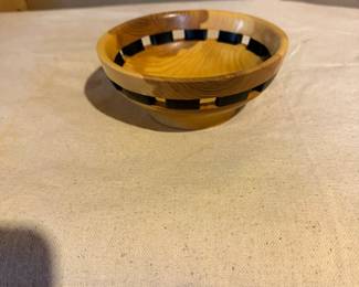 Handcrafted segmented wood bowl with decorative black accent banding. A beautiful display piece showcasing fine woodturning and exotic hardwoods.