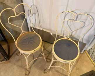 Pair of decorative white wrought iron garden chairs with heart back design. Great for patio, porch, garden, sunroom, or decorative display.