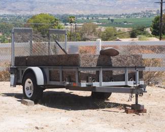 Single-axel utility trailer. 5x8 ft bed. Fold-down ramp gate.