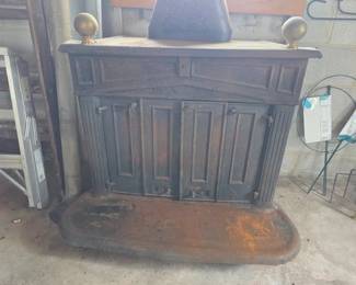 Large, extremely heavy wood stove with folding front double doors and brass finials