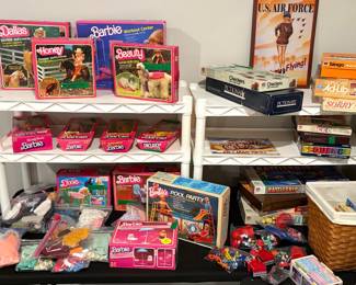 Collection of vintage 1980s Mattel Barbies with original packaging, PawPatrol toys, and other classic board games. 