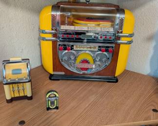 Polyconcept 1997 vintage-style jukebox features a built-in CD player and AM/FM radio, housed in a wood-toned cabinet with yellow accents
