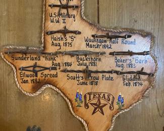 vintage Texas plaque with a collection of labeled barbed wire from 1875