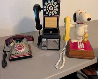 Vintage-style novelty phones. The central black rotary wall pay phone resembles a Crosley 1950's replica model