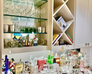 STOCKED BAR WITH COOL DECANTERS AND STEMWARE.