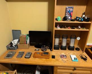 Assorted Desk Items: Calculators, Lamps, Digital Camera, Smart Watch, and Desk Accessories