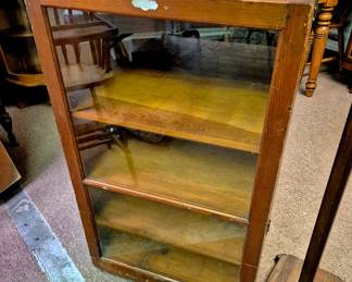 Glass display cabinet that opens in the middle, on rollers