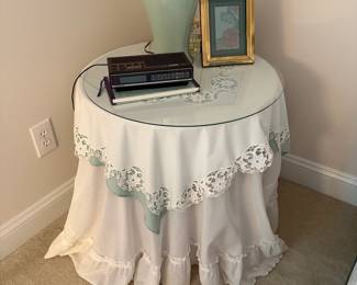 C38 - $25. Glass Top Bedside Table with Shelf. Includes linens.