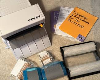 C64 - $20. Xyron 850 Laminating System. Has laminating paper loaded, an extra cartridge and a 2" & 4" adhesive runner with refills.