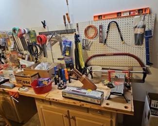 Assorted Workshop Tools and Supplies including Miter Saw, Bow Saw, Grease Gun, and Pegboard Organization