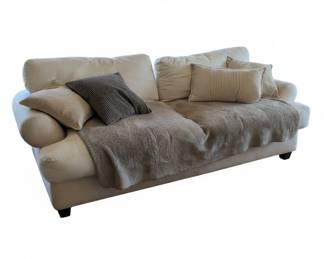 White Fabric Sofa with Throw Pillows and Blanket