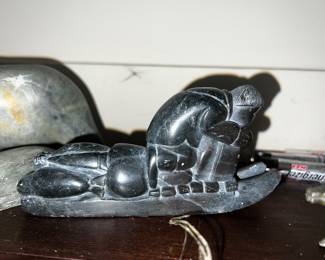 inuit hand carved figurine of hunter on a sled with dogs