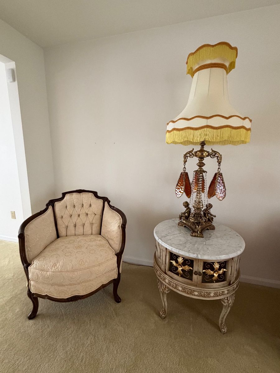 One of two Victorian barrel chairs, Italian marble top table and vintage Loevsky & Loevsky Hollywood Regency lamp with Strauss crystals.