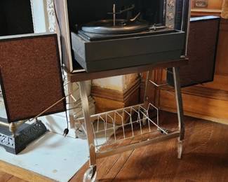 Vintage Sylvania Solid State portable stereo system with Garrard turntable and metal record storage rack on wheels
