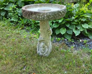 Beautiful concrete bird bath with bear scene on bottom.