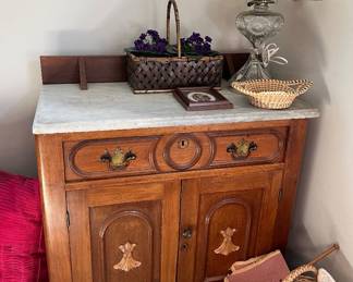 Victorian marble top washstand is crafted from carved walnut with distinct floral motifs.