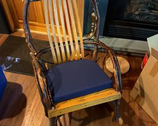 Amish hickory bentwood rocking chair features a tall, curved slat back made from steam-bent twigs and a blue fabric seat cushion